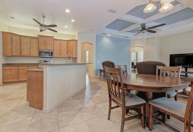 dining room featuring sink, coffered ceiling, light tile patterned flooring, and ceiling fan with notable chandelier