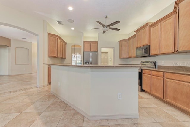 kitchen with ceiling fan, stainless steel appliances, a center island, and light tile patterned flooring