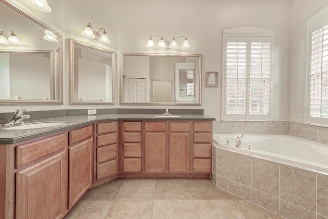 bathroom featuring vanity, a relaxing tiled tub, and tile patterned floors