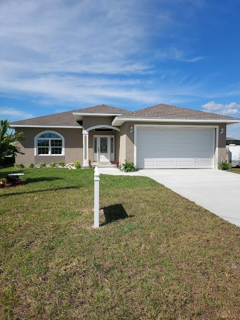 view of front of property featuring a front lawn and a garage