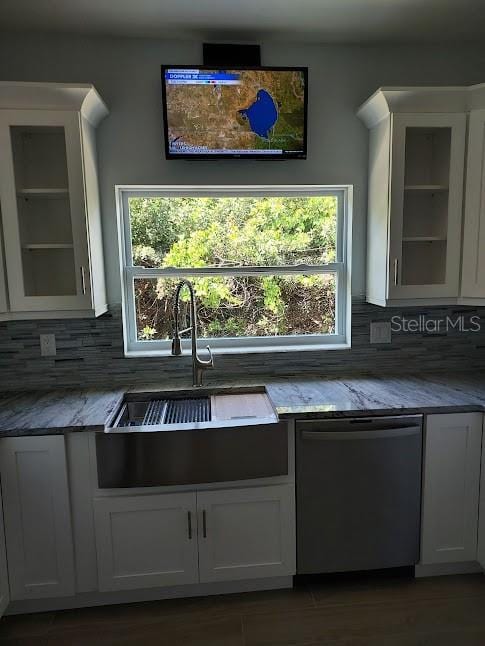 kitchen with sink, a wealth of natural light, stainless steel dishwasher, and white cabinets