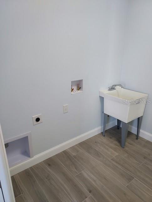 clothes washing area with washer hookup, hardwood / wood-style flooring, and electric dryer hookup