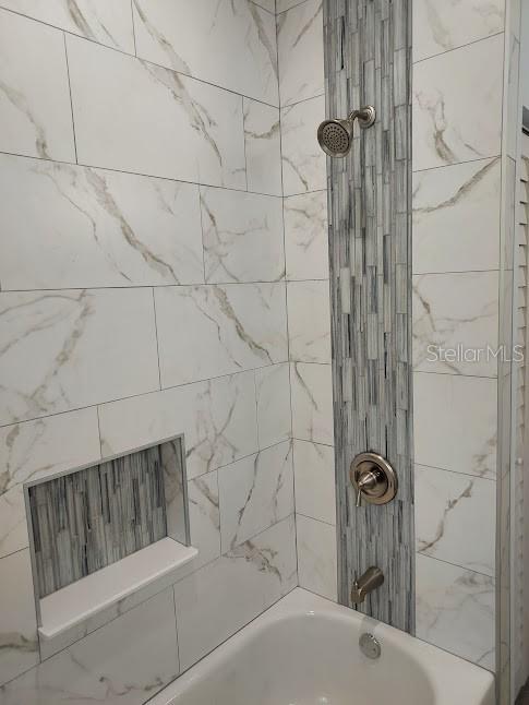 bathroom featuring tiled shower / bath