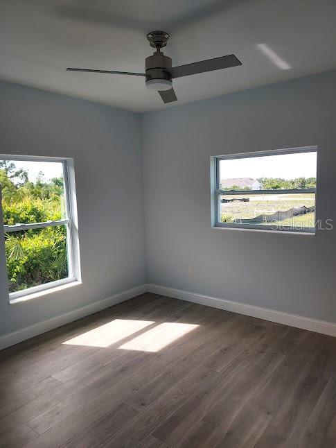 spare room with ceiling fan and dark hardwood / wood-style flooring