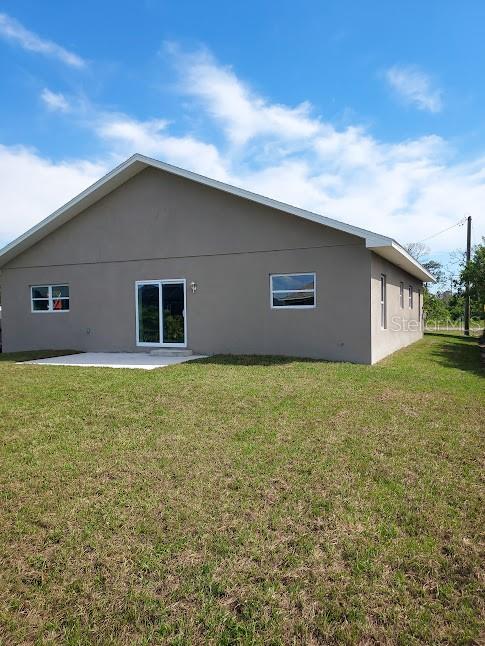 back of property with a patio and a lawn