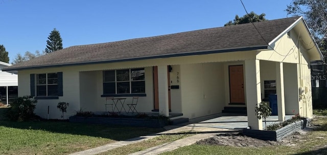 view of front facade with entry steps, a shingled roof, and a front lawn