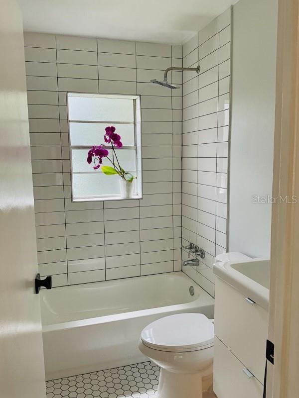 full bath featuring shower / bath combination, vanity, toilet, and tile patterned floors