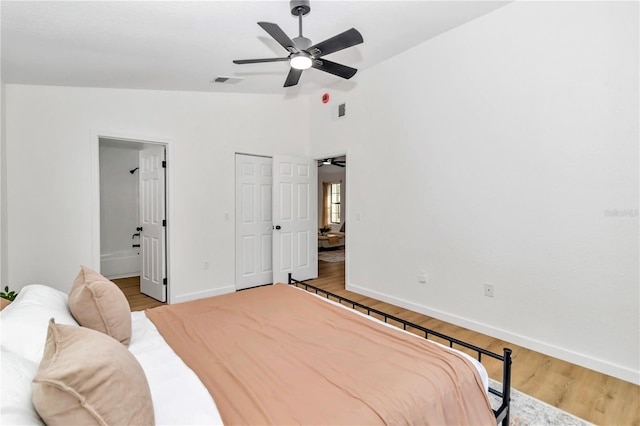 bedroom with ceiling fan, light hardwood / wood-style flooring, and vaulted ceiling