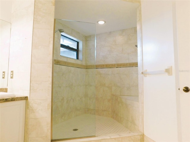 bathroom with vanity and a tile shower