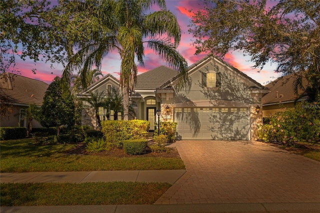 view of front of property featuring a garage and a yard