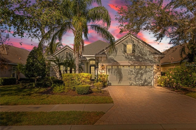 12121 Thornhill Ct, Lakewood Ranch, FL 34202 - view of front of house featuring decorative driveway, an attached garage, stucco siding, and a tiled roof