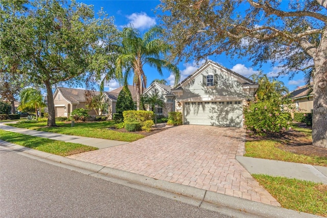 12121 Thornhill Ct, Lakewood Ranch, FL 34202 - view of front of property with decorative driveway, a front yard, stucco siding, and a garage