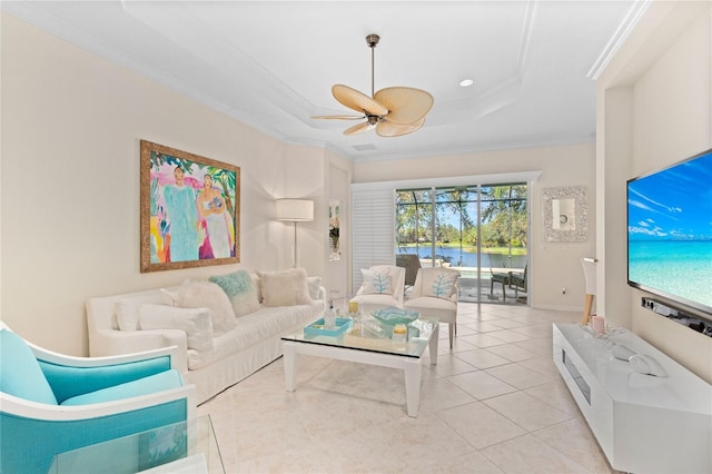 living room with a tray ceiling, ceiling fan, crown molding, and light tile patterned flooring