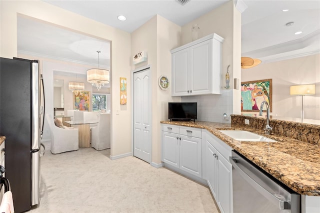 12121 Thornhill Ct, Lakewood Ranch, FL 34202 - kitchen featuring appliances with stainless steel finishes, a sink, white cabinets, light stone countertops, and ornamental molding