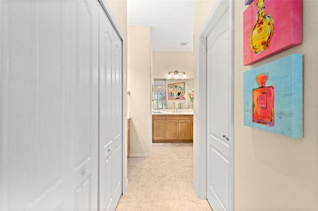 12121 Thornhill Ct, Lakewood Ranch, FL 34202 - corridor with light tile patterned floors, a sink, and baseboards