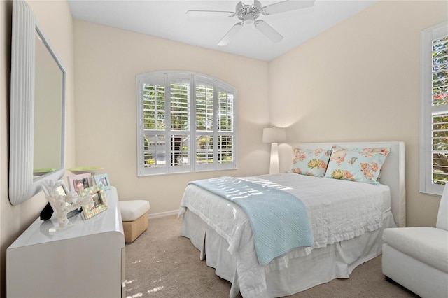 carpeted bedroom featuring ceiling fan and multiple windows