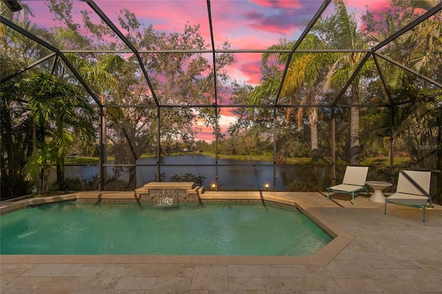 pool at dusk with a lanai, pool water feature, a water view, and a patio