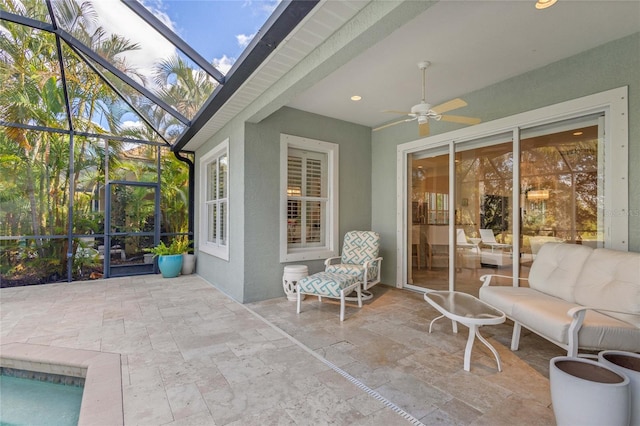 view of patio / terrace featuring outdoor lounge area, glass enclosure, and ceiling fan