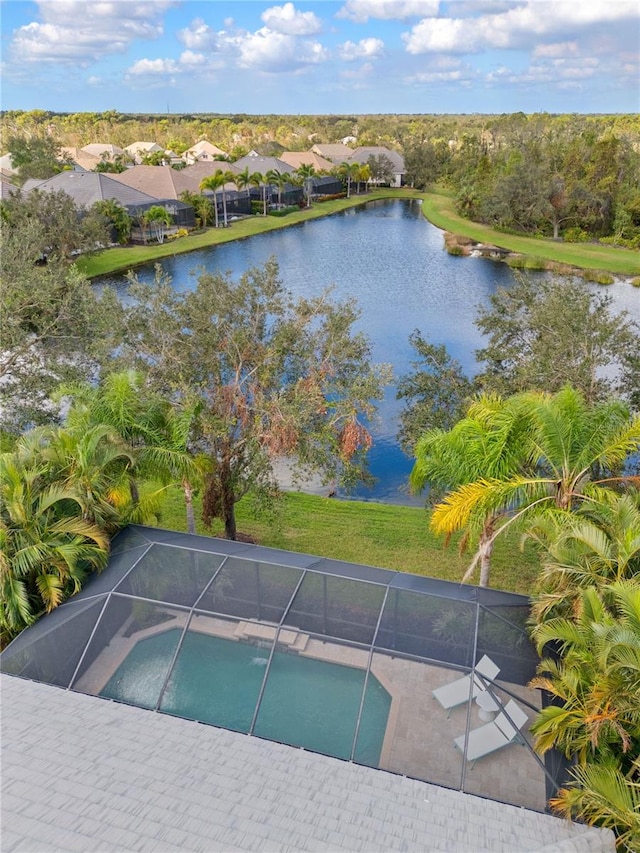 view of pool with glass enclosure, a patio area, and a water view