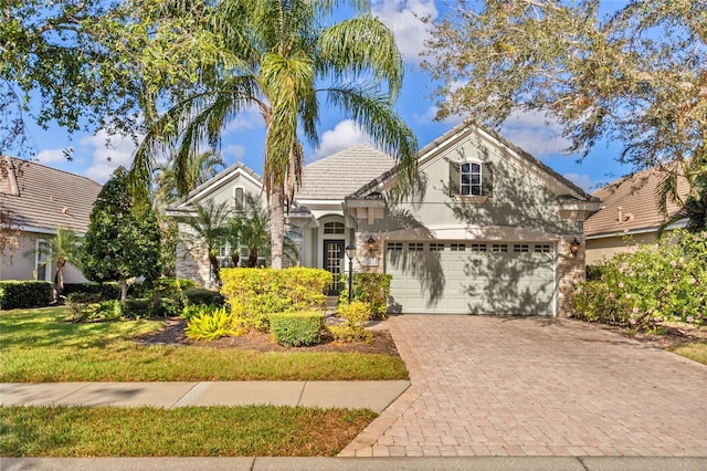 12121 Thornhill Ct, Lakewood Ranch, FL 34202 - view of front facade with decorative driveway, stucco siding, a tiled roof, and a garage