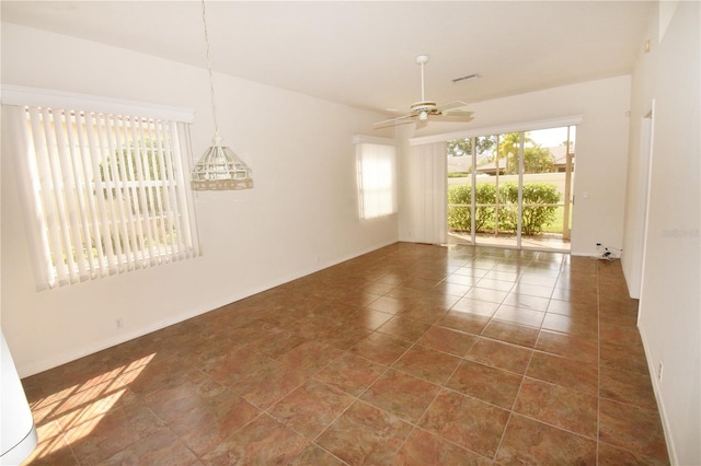 unfurnished room featuring dark tile patterned floors and ceiling fan