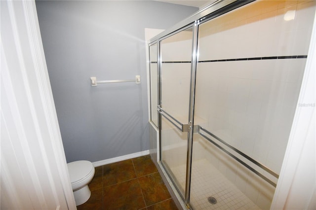 bathroom featuring toilet, walk in shower, and tile patterned flooring