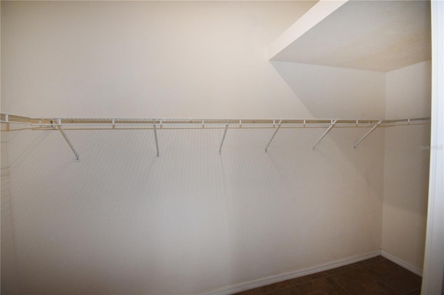 walk in closet featuring dark tile patterned flooring