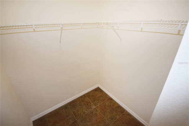 walk in closet featuring dark tile patterned floors