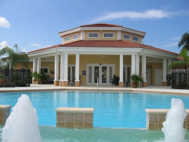 view of swimming pool with pool water feature, french doors, and a patio