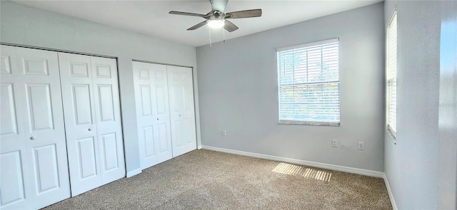 unfurnished bedroom with ceiling fan, carpet, and multiple closets