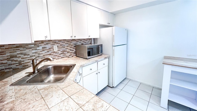 kitchen with white cabinetry, white fridge, sink, and backsplash