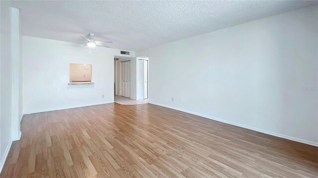 spare room with light hardwood / wood-style flooring, a textured ceiling, and ceiling fan