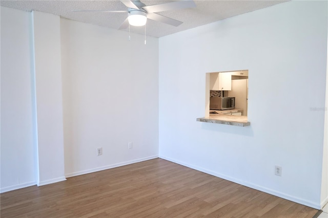 unfurnished room with hardwood / wood-style floors, a textured ceiling, and ceiling fan