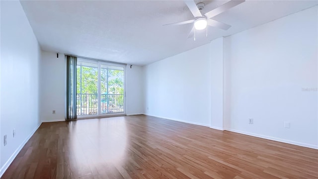 empty room with hardwood / wood-style floors and ceiling fan