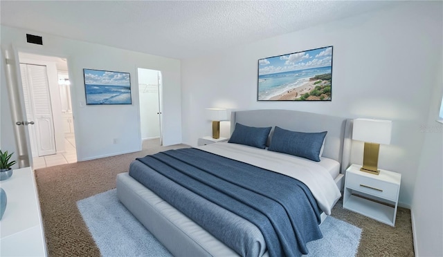 carpeted bedroom featuring a textured ceiling and ensuite bathroom