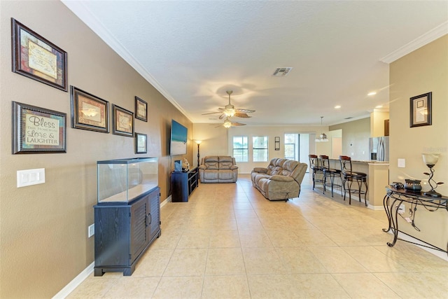 living room with crown molding, light tile patterned floors, and ceiling fan