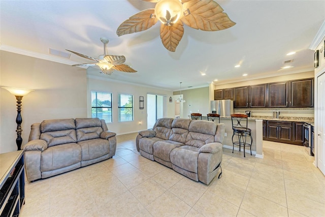 tiled living room with crown molding and ceiling fan