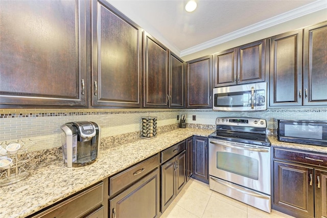 kitchen with appliances with stainless steel finishes, ornamental molding, light stone countertops, and dark brown cabinetry