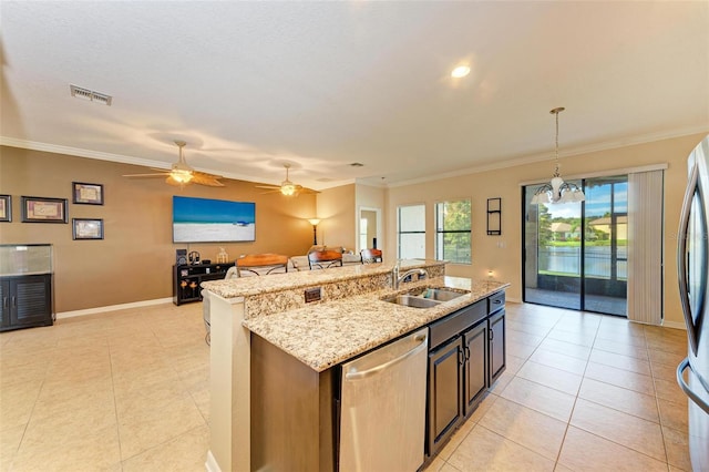 kitchen featuring an island with sink, crown molding, sink, decorative light fixtures, and appliances with stainless steel finishes