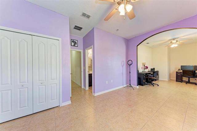 office space with ceiling fan, a textured ceiling, and light tile patterned flooring