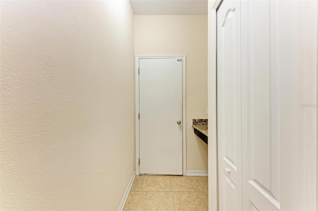 hall featuring light tile patterned floors