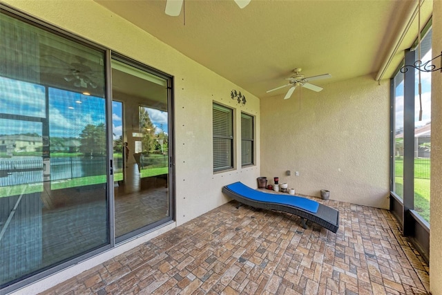 unfurnished sunroom featuring a wealth of natural light and ceiling fan