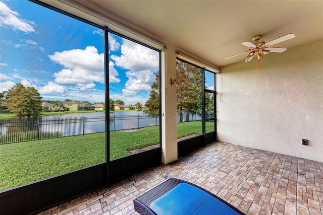 unfurnished sunroom featuring a water view and ceiling fan