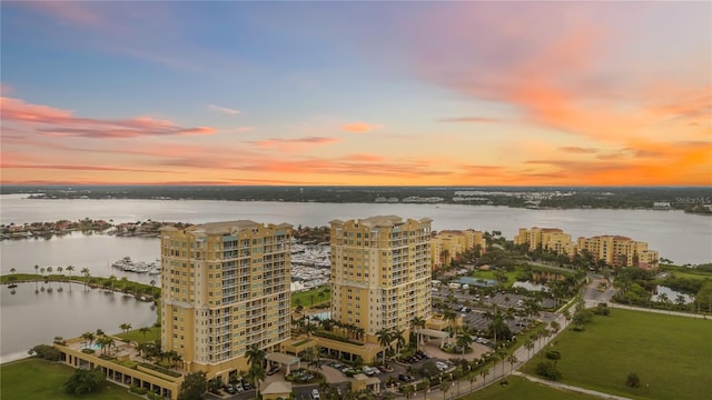 aerial view at dusk featuring a water view