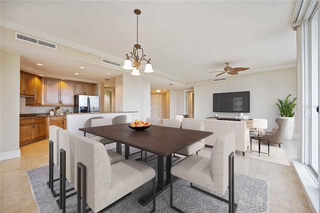 tiled dining area with ornamental molding and ceiling fan with notable chandelier