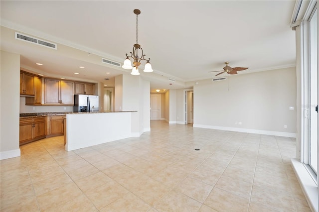 kitchen with ceiling fan with notable chandelier, stainless steel fridge, decorative light fixtures, ornamental molding, and light tile patterned floors