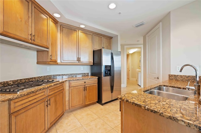 kitchen featuring appliances with stainless steel finishes, light tile patterned flooring, sink, and stone countertops