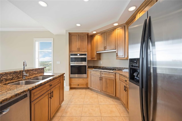 kitchen with stone countertops, stainless steel appliances, sink, and light tile patterned floors