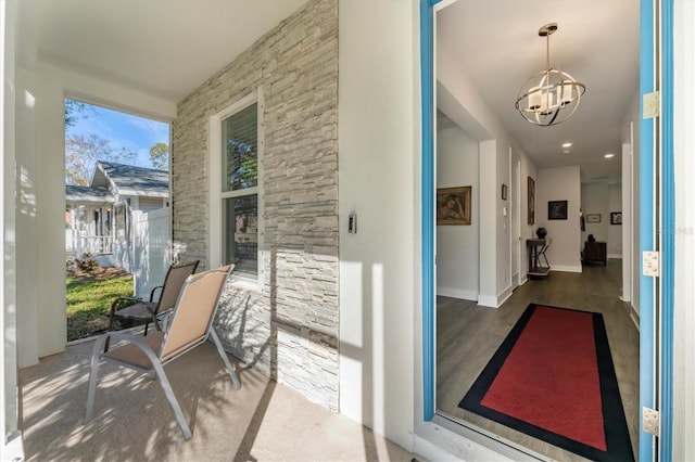 interior space with baseboards, wood finished floors, and a chandelier