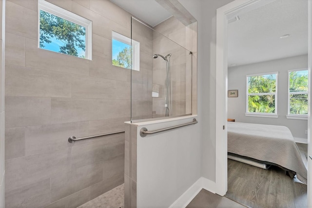 full bathroom featuring a walk in shower, ensuite bathroom, baseboards, and wood finished floors